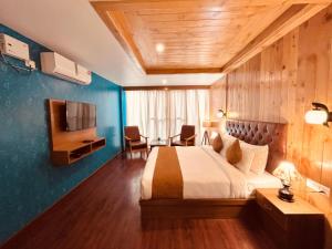 马拉里Vista Resort, Manali - centrally Heated & Air cooled luxury rooms的酒店客房配有一张床、一张书桌和一台电视。