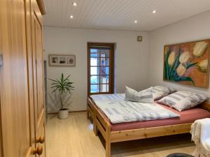 库拉萨Hos Franz的卧室配有一张床,墙上挂有绘画作品