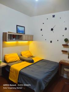 TekoZye Rooms apartemen的卧室配有一张床,墙上挂着一个钟