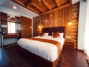 马拉里Vista Resort, Manali - centrally Heated & Air cooled luxury rooms的一间卧室配有一张带木墙的大床