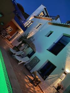 AcequiasCasa Morayma, Lecrin, Granada (Adult Only Small Guesthouse)的一座白色的大建筑,配有椅子和遮阳伞