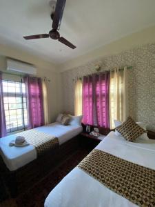索拉哈Hotel Safari Suite的一间卧室配有两张床和粉红色窗帘