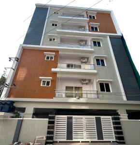 海得拉巴Mee Homes - Madhapur Fully Furnished 2 BHK Flats的一座高大的建筑,旁边设有阳台