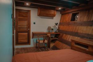 纳闽巴霍DAV Travels的一间卧室设有木墙、桌子和书桌