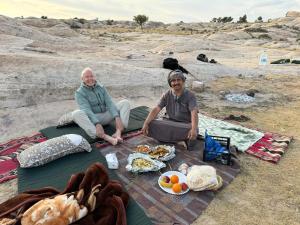 达纳达纳塔酒店的两个人坐在毯子上,野餐