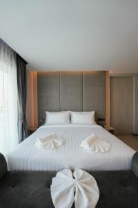 合艾โรงแรมออร่า สงขลา的一张白色的大床,上面有弓形装饰