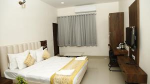 AyodhyaGoroomgo Hotel The Nirmala Palace Ayodhya-Near Ram Mandir的酒店客房,配有床和电视