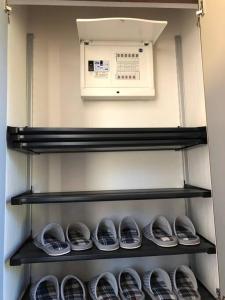 志摩市森の空気を感じる宿泊 露天風呂 Wi-Fi 最大20名様的冰箱里架子上的一排鞋