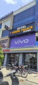 艾哈迈达巴德Hotel Avadh Palace RTO Circle Ahmedabad的停在大楼前的一排摩托车