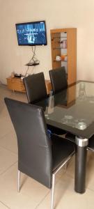科托努BG archange的客房内的餐桌和椅子以及电视