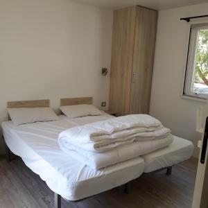 雷岛林滩Village Océanique的一间卧室配有一张带白色床单的床和一扇窗户。
