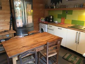 AnianeAu Rendez-Vous des Sorciers II的厨房配有木桌和冰箱。