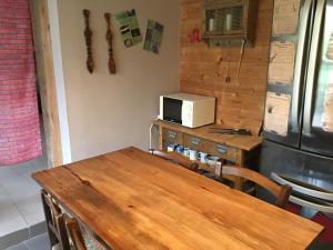 AnianeAu Rendez-Vous des Sorciers II的厨房配有木桌和微波炉