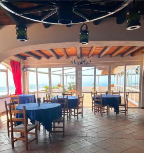 伊斯基亚Hotel Punto Azzurro的一间配备有蓝色桌椅的海景餐厅