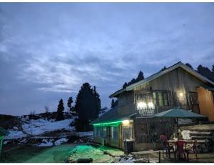古尔马尔格Hotel Nagview Cottage, Jammu and Kashmir的雪中带绿灯的房子
