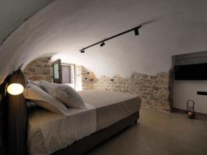 阿里奥波利斯Sophia Town Square Areopoli的石墙客房的卧室配有一张床