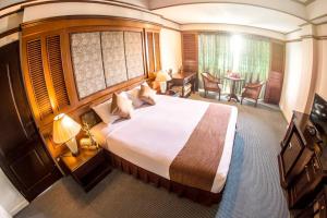 南邦Lampang Wieangthong的酒店客房设有一张大床和一张桌子。