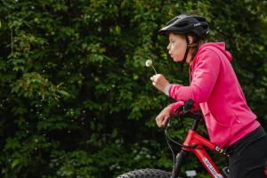 洛斯托拉普兰罗斯托图恩图瑞酒店及紫水晶Spa的骑自行车吃花的年轻女孩