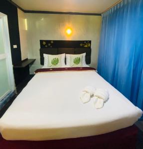 攀牙帕科尔精品度假酒店的卧室配有带毛巾的大型白色床
