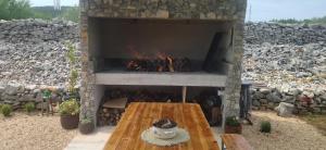 沃迪切House for rest Juricev的石头壁炉,配有桌子和火坑