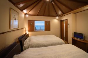 鹤冈市尤拉温泉八乙女日式旅馆 的小型客房 - 带2张床和窗户