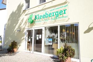 普莱因费尔德Gästehaus Kleeberger的建筑物一侧有标志的商店