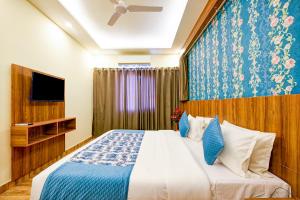 新德里Balwood Suites Near Delhi Airport的一间卧室配有一张床和电视