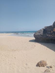 Calheta Do MaioA.M.A Appartament的沙滩上沙地里岩石