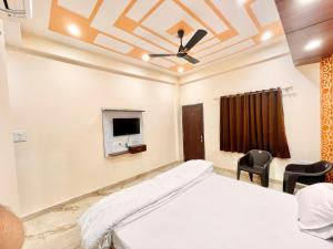 瓦拉纳西Hotel Sunayana Guest House ! Varanasi fully-Air-Conditioned hotel at prime location, near Kashi Vishwanath Temple, and Ganga ghat的一间卧室设有一张床,天花板上配有电视。