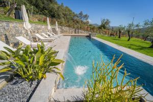 东塞斯特里Villa Chicchi - Sestri Levante的一个带躺椅的游泳池和一个喷泉