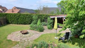吕本瑙Ferienhaus Berndt im Spreewald的花园配有黄色遮阳伞和椅子