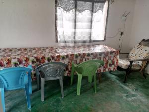 拉穆Tabassam Guest House的配有椅子和桌子的房间以及窗户
