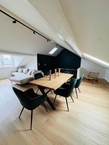 列日Duplex hyper centre的一间带木桌和绿色椅子的用餐室
