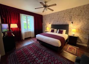 La Bégude-de-MazencLe Mas Des Abeilles - Chambres d'hôtes的一间卧室配有一张带红色窗帘的大床