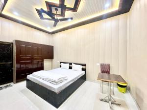 瓦拉纳西Hotel DEV VILLA GUEST HOUSE ! VARANASI fully-Air-Conditioned hotel at prime location, near Kashi Vishwanath Temple, and Ganga ghat的一间卧室设有一张床铺、一张桌子和天花板