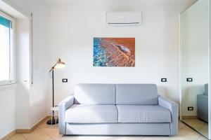 费拉约港Appartamento Il Mare e Dintorni的客厅配有沙发和墙上的绘画