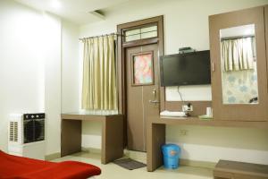 博帕尔Hotel Neelkanth , Bhopal的一间配有电视的房间和一扇窗户的门