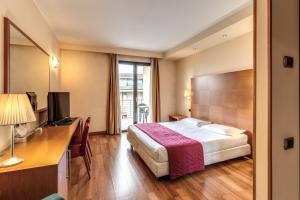 奥雷吉奥卡斯特罗Luna Hotel Motel Lago Maggiore Arona的配有一张床和一张书桌的酒店客房