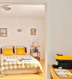 卡布勒通Maison Notre Dame des Apôtres的一间卧室配有一张带黄色枕头的床和电视。