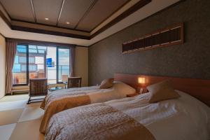 河津町Isoaruki no Yuyado Ushiogumo -6 years or older-的一间卧室设有两张床和大窗户