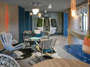 盖拉德安马斯日内瓦门美居酒店的一间带椅子、桌子和面包车的房间