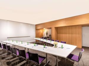 阿比让阿比让诺富特酒店的大型会议室,配有长桌和紫色椅子