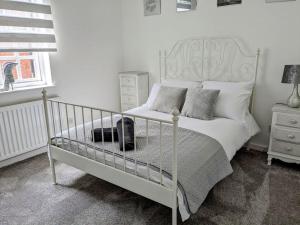 科尔切斯特Cosy Home in City Centre的卧室配有白色的床和窗户。
