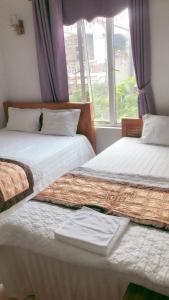 河内Huy Hoang Airport的带窗户的客房内设有两张单人床。