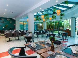 塔那那利佛宜必思塔那那利佛安科罗德拉诺酒店的餐厅设有桌椅和玻璃天花板。