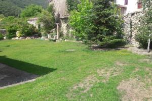 ButreraEl Refugio de Santi的一座带草地庭院的古老石头房子