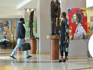 金沙萨金沙萨格兰德铂尔曼酒店的走过博物馆雕像的男女