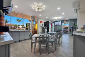 好莱坞Quality Inn & Suites Airport-Cruise Port Hollywood的厨房里设有1间带桌椅的餐厅