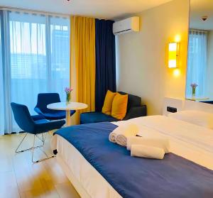 巴统Sea View Panoramic Suite Orbi City的酒店客房带两张床和一张桌子以及椅子。