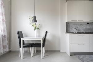 哥德堡Live and Stay Lagerbring的一张带两把椅子的白色桌子和花瓶